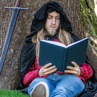 man with sword under tree reading about what is larp